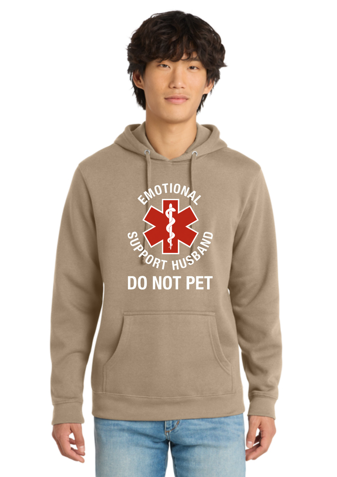 A man wearing an olive green pullover hoodie with a red and white graphic that reads 'EMOTIONAL SUPPORT HUSBAND DO NOT PET' on the front, paired with blue jeans, against a plain white background.