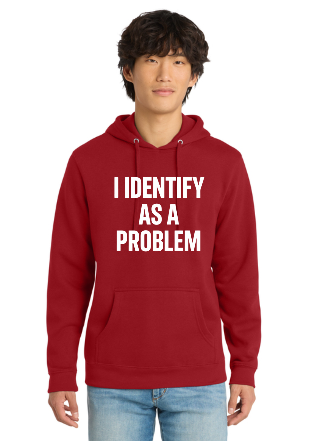 A man wearing a red pullover hoodie with the text 'I IDENTIFY AS A PROBLEM' printed in white capital letters on the front, paired with light blue jeans, against a plain white background.