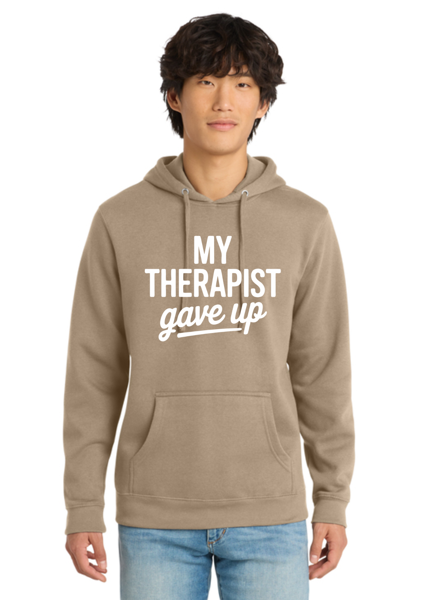 A man wearing an olive green pullover hoodie with the white printed text 'MY THERAPIST gave up' on the chest, paired with light blue jeans, against a plain white background.