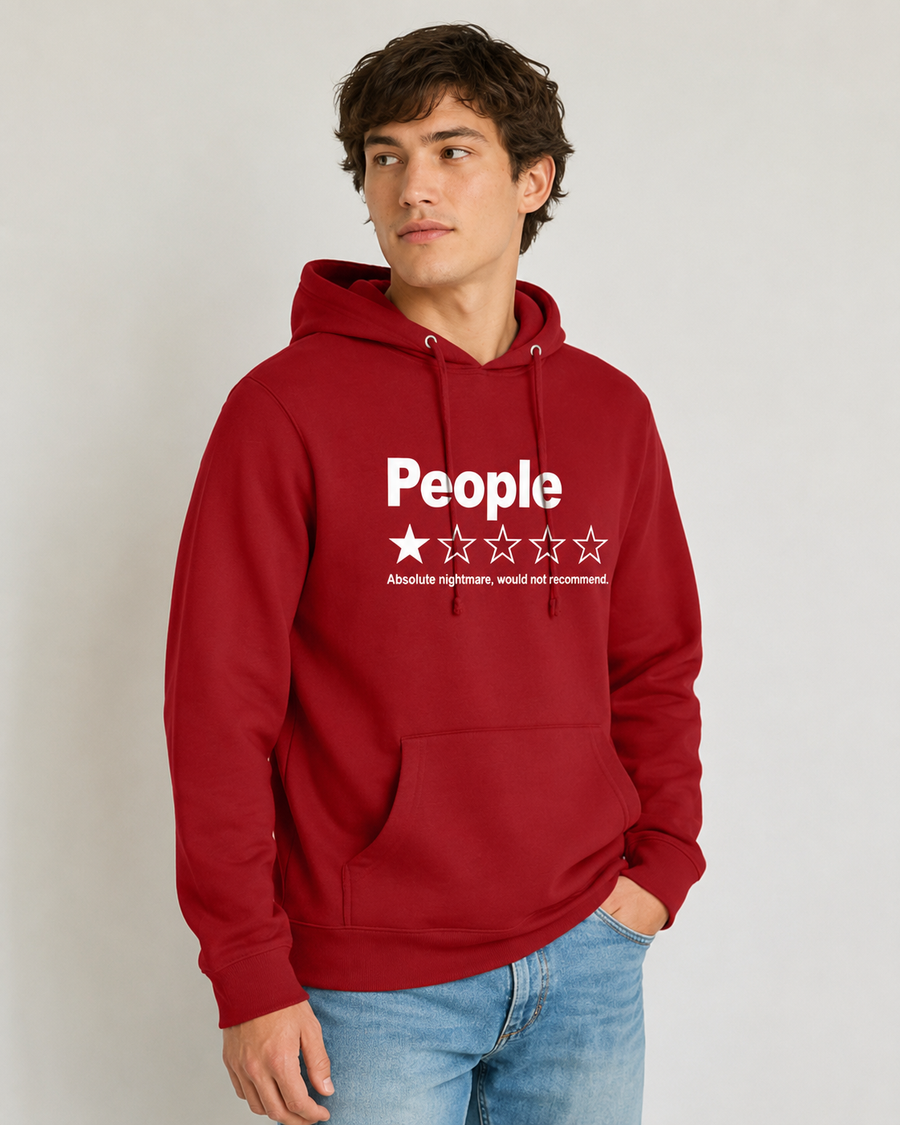 A man wearing a red pullover hoodie with a white graphic print that reads 'People' above five stars and the phrase 'Absolutely nothing, would not recommend.' He is also wearing blue jeans against a plain light gray studio background.
