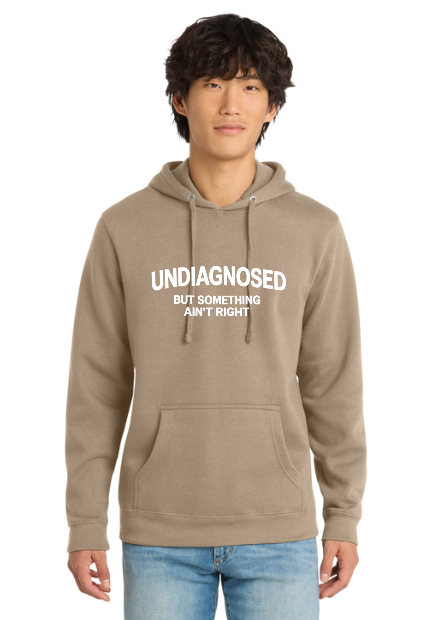 A man wearing an olive green pullover hoodie with white text on the chest that reads 'UNDIAGNOSED BUT SOMETHING AIN'T RIGHT', paired with blue jeans, against a plain white background.