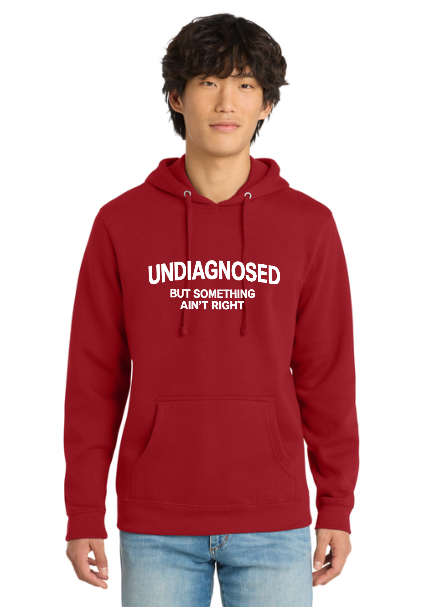 A man wearing a red pullover hoodie with the text 'THESE HOES DON'T DESERVE ME' printed in white capital letters on the chest, paired with blue jeans, against a plain white background.
