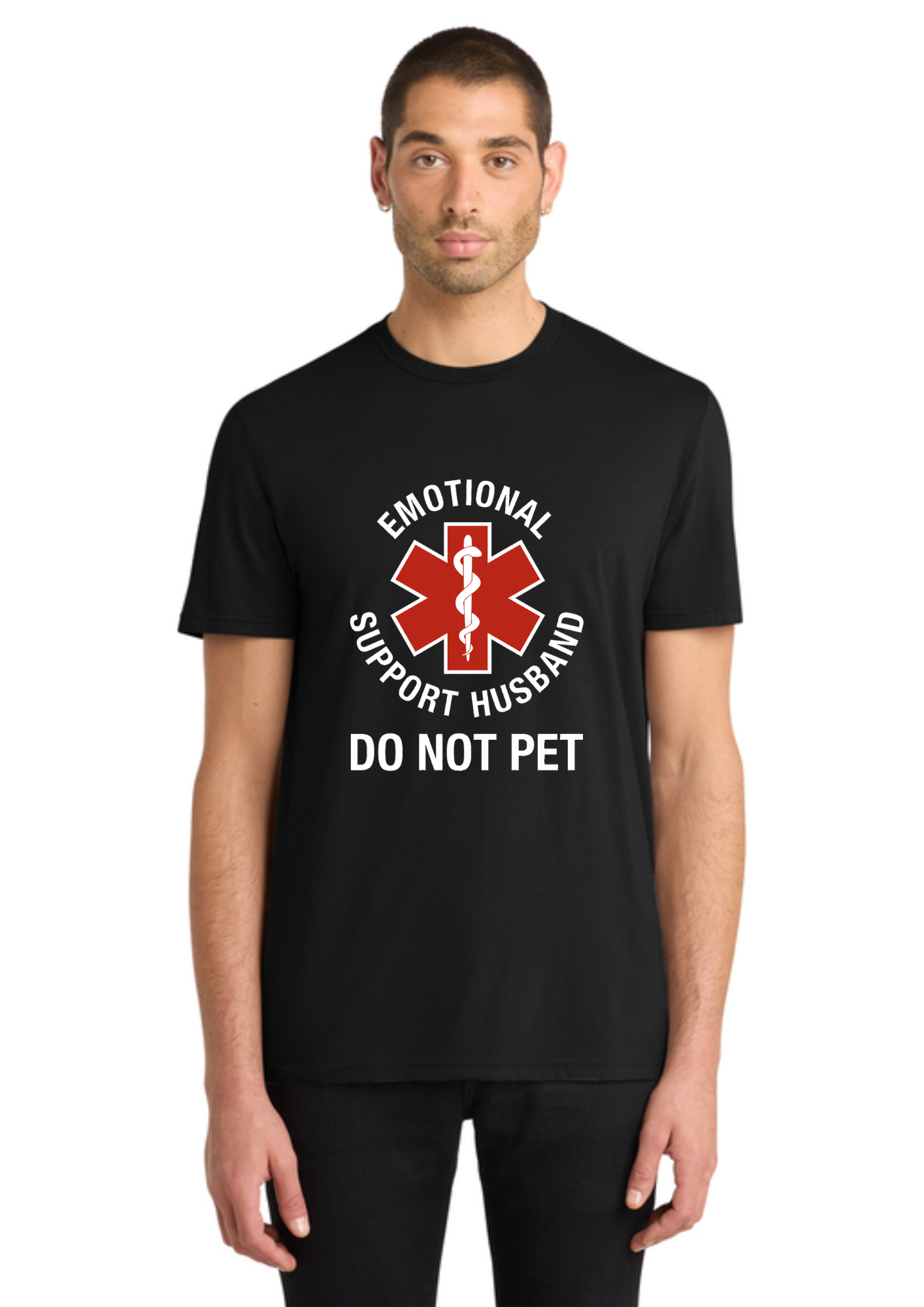 A man wearing a black short-sleeve t-shirt with a graphic print that reads 'EMOTIONAL SUPPORT HUSBAND DO NOT PET' around a red and white star-of-life style medical symbol, shown against a plain white background.