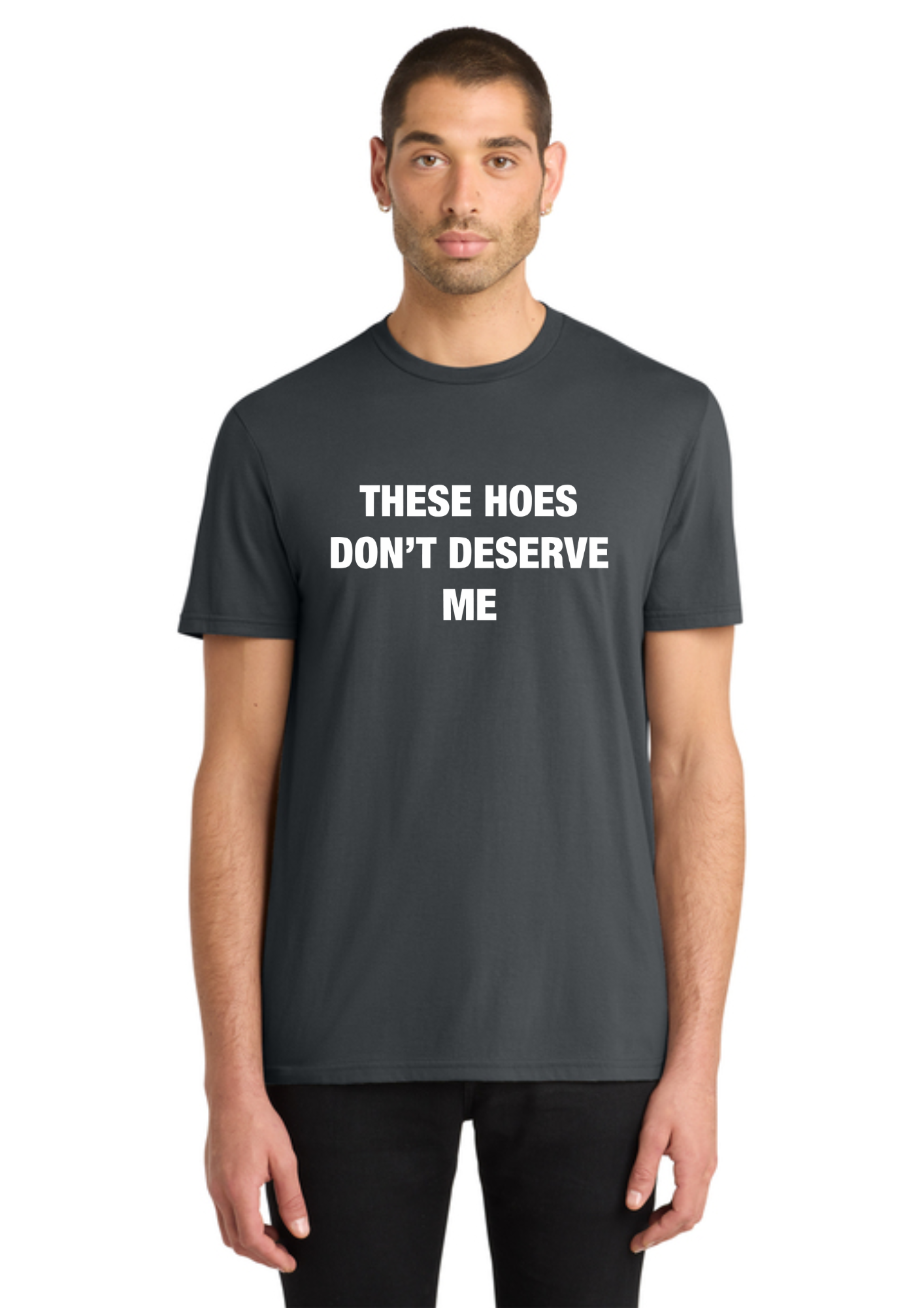 A man wearing a dark gray crewneck t-shirt with the white printed text 'THESE HOES DON'T DESERVE ME' on the chest, set against a plain white background.